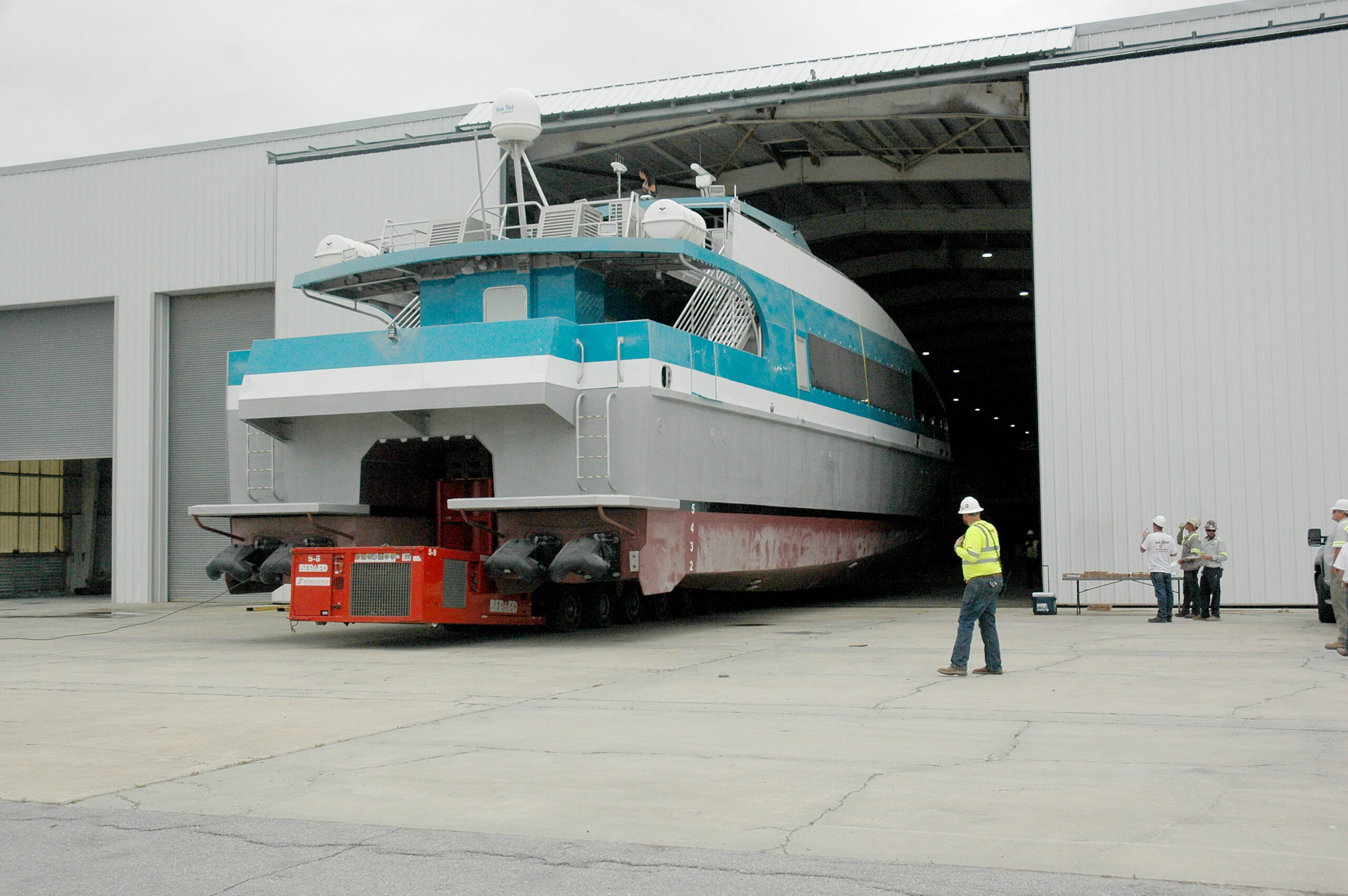 Aluminum ferry boat moving out of building to launch 